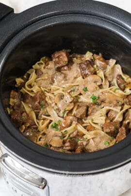 Crockpot beef stroganoff in a Crock-Pot with parsley on top