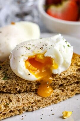 a poached egg broken open over toast