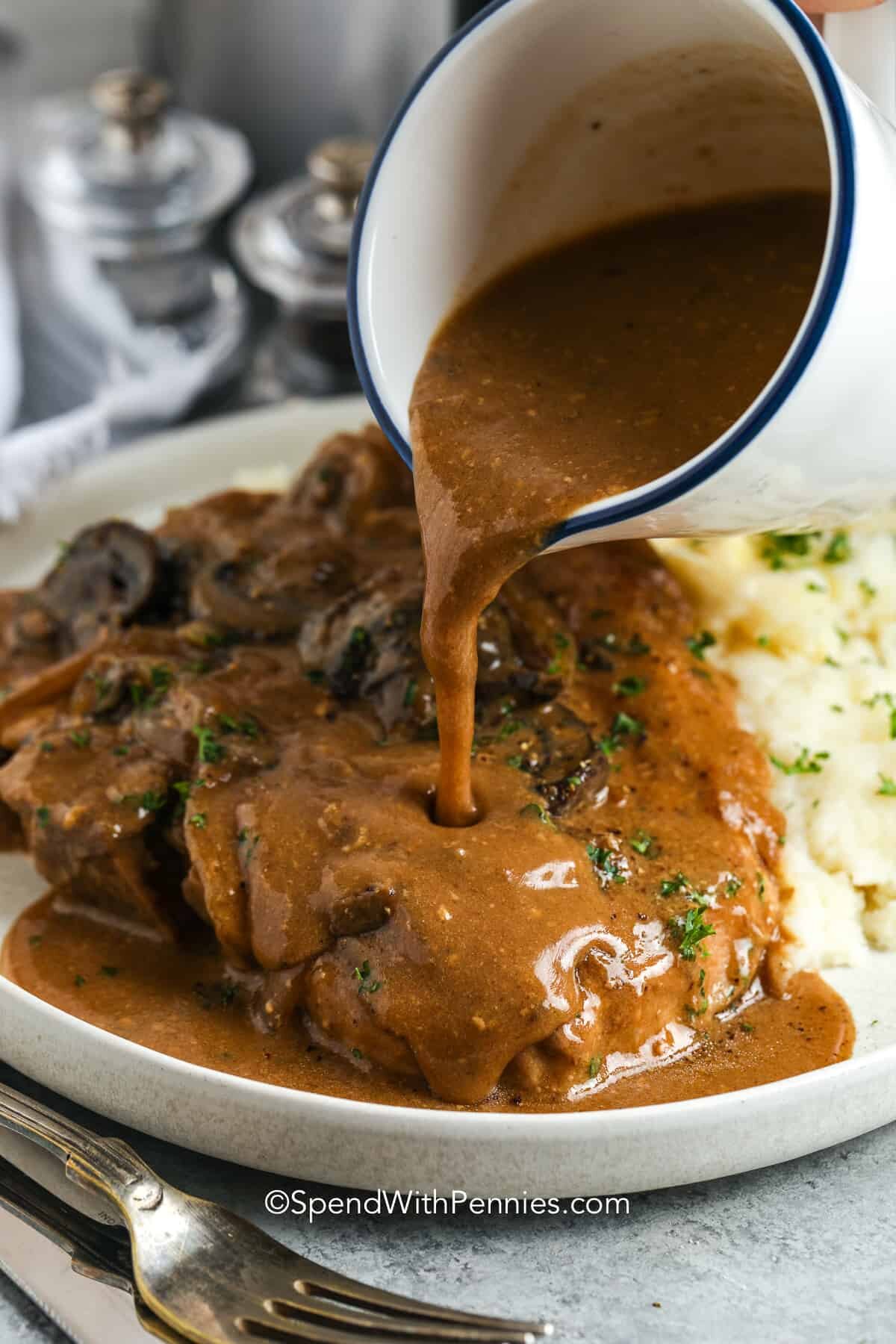 pouring gravy over Crock Pot Pork Chops