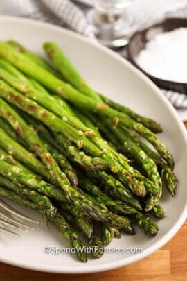 a plate of roasted asparagus with salt and pepper