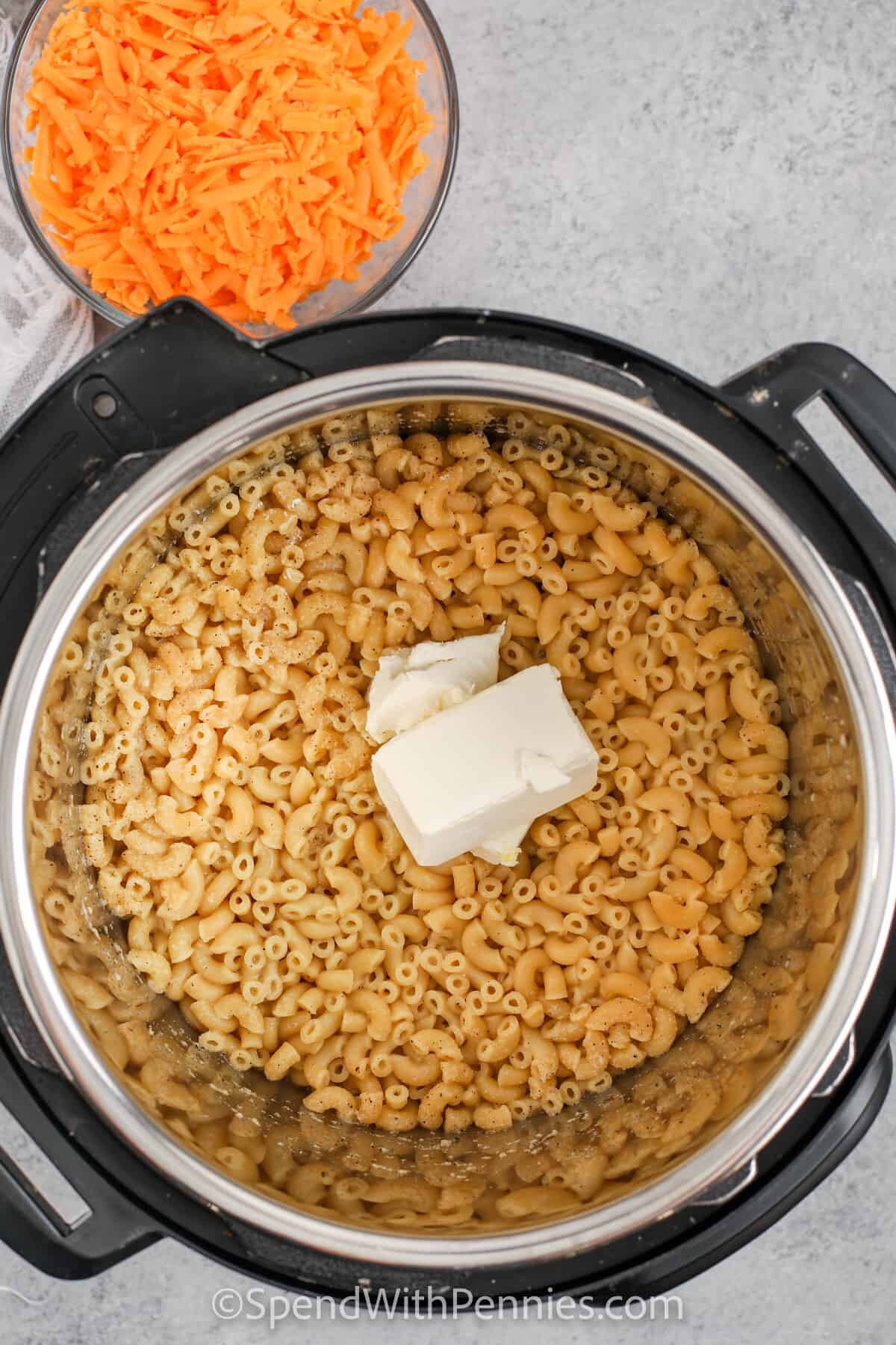 Mac with cream cheese being added to the instant pot