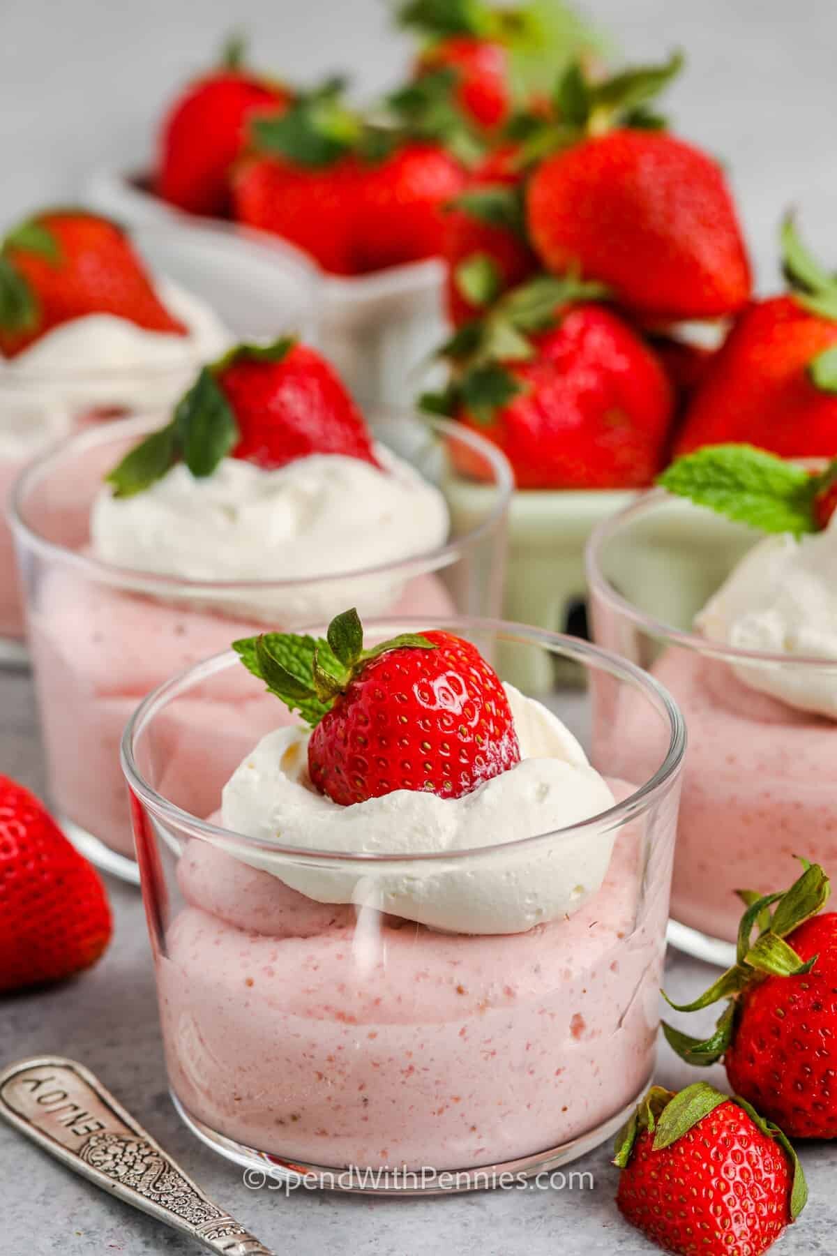 Homemade Strawberry Mousse in cups with whipped cream and extra strawberries