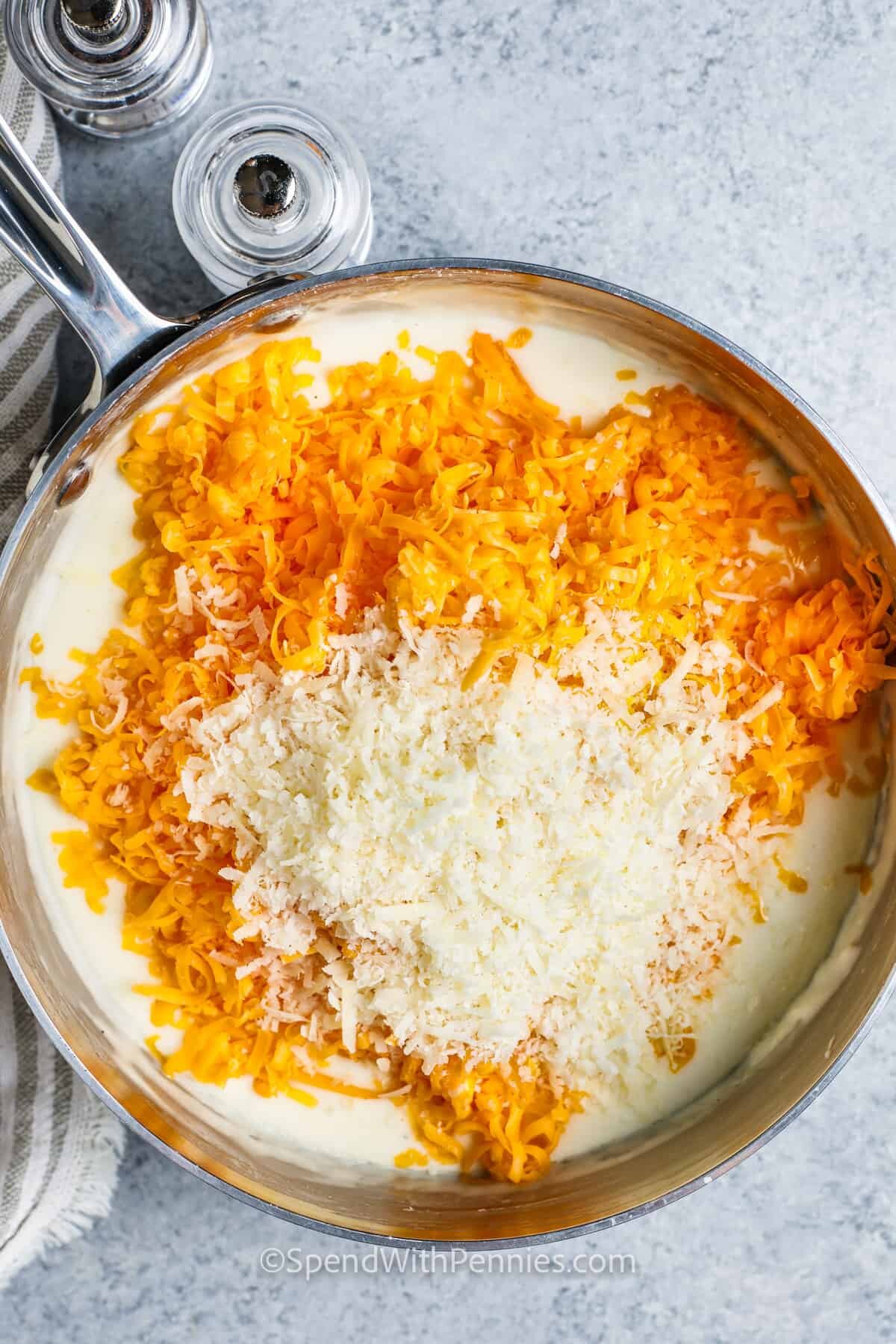 adding cheese to pot to make Baked Mac and Cheese