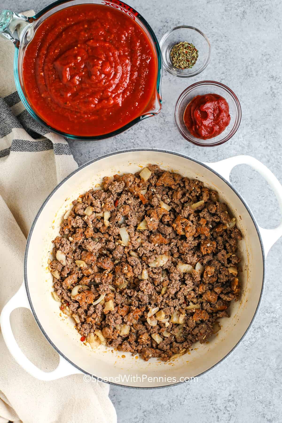 a pot of cooked meat and a bowl of pasta sauce for lasagna