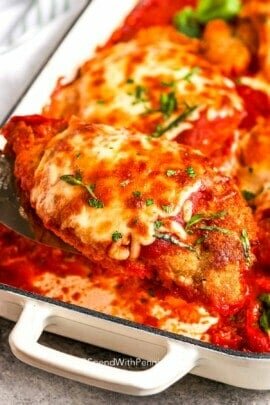 serving a baked chicken parmesan from a casserole dish