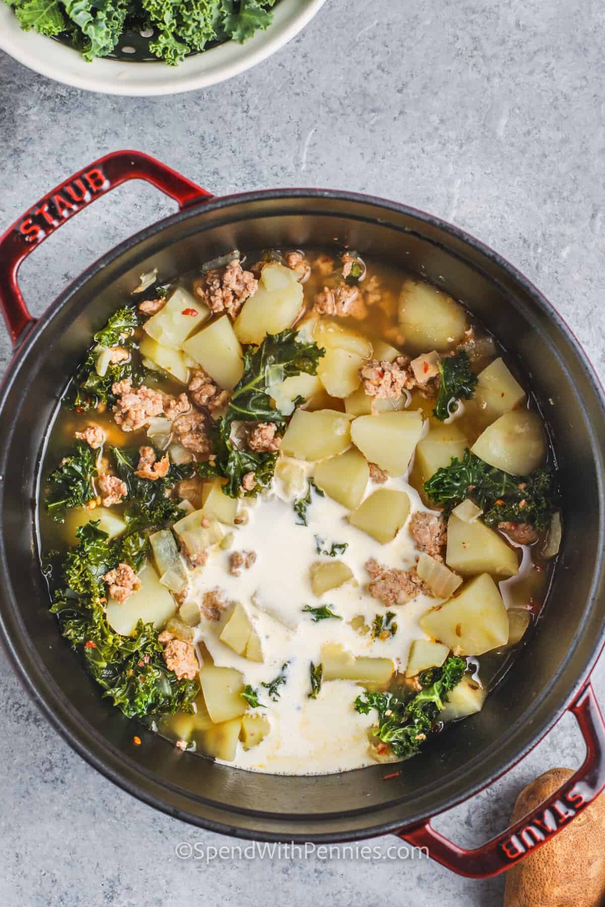 adding cream to ingredients to make Zuppa Toscana