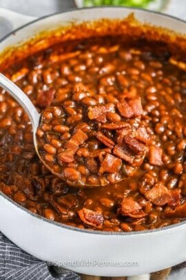 taking a spoonfull of The Best Baked Beans out of the pot